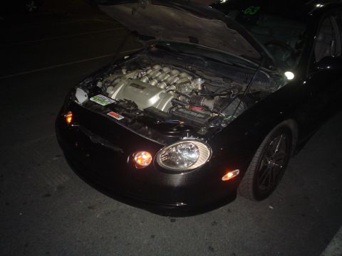 1993 Ford Taurus - Front view of a black 1993 Ford Taurus with its hood open, displaying the engine compartment.