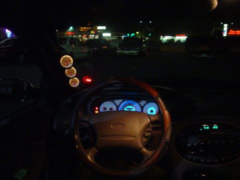 1993 Ford Taurus - The interior of a 1993 Ford Taurus is visible at night, with illuminated gauges and a steering wheel.