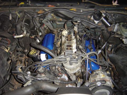 1998 Ford Taurus - Close-up view of a vehicle's engine bay, highlighting various components and wiring.