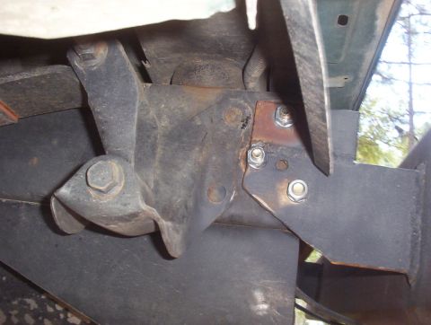 1989 Ford Bronco - Close-up view of a rusted metal bracket and bolts on a vehicle's undercarriage.