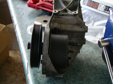 1996 Ford Bronco - A power steering pump assembly is secured in a vise on a workbench, ready for service.