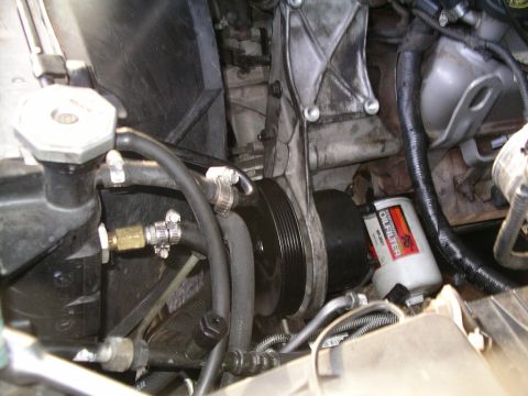 1996 Ford Bronco - Close-up view of an engine bay, showing an oil filter, radiator, and various hoses and belts.