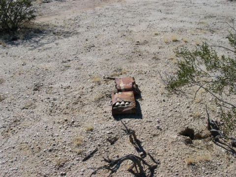 1994 Ford Bronco - Debris lies scattered across a desolate desert landscape.