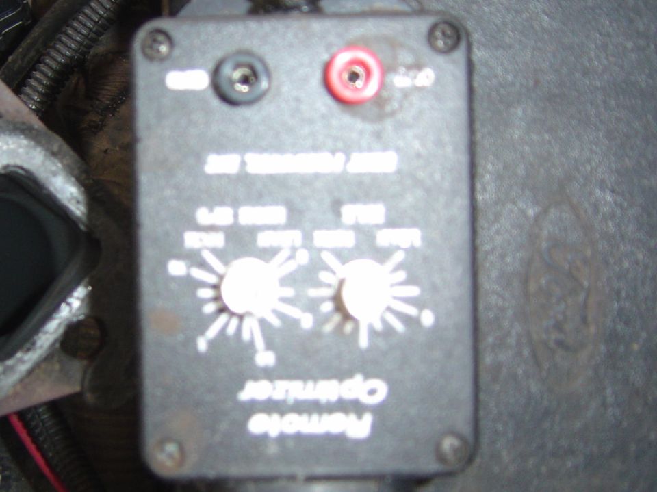 Close-up of a black box labeled 'Remote Optimizer' with two knobs and red/black terminals