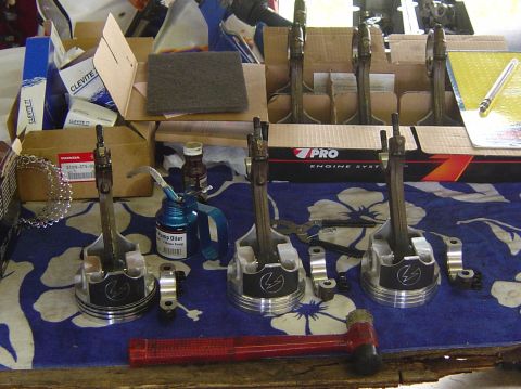 1993 Ford Bronco - Engine pistons and connecting rods laid out with various automotive parts and tools.