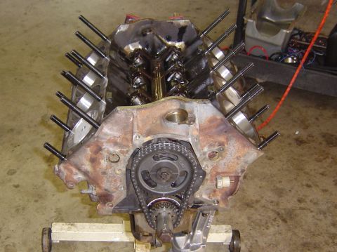 1993 Ford Bronco - Engine block with timing chain and sprockets is shown, mounted on a stand for repair or inspection.