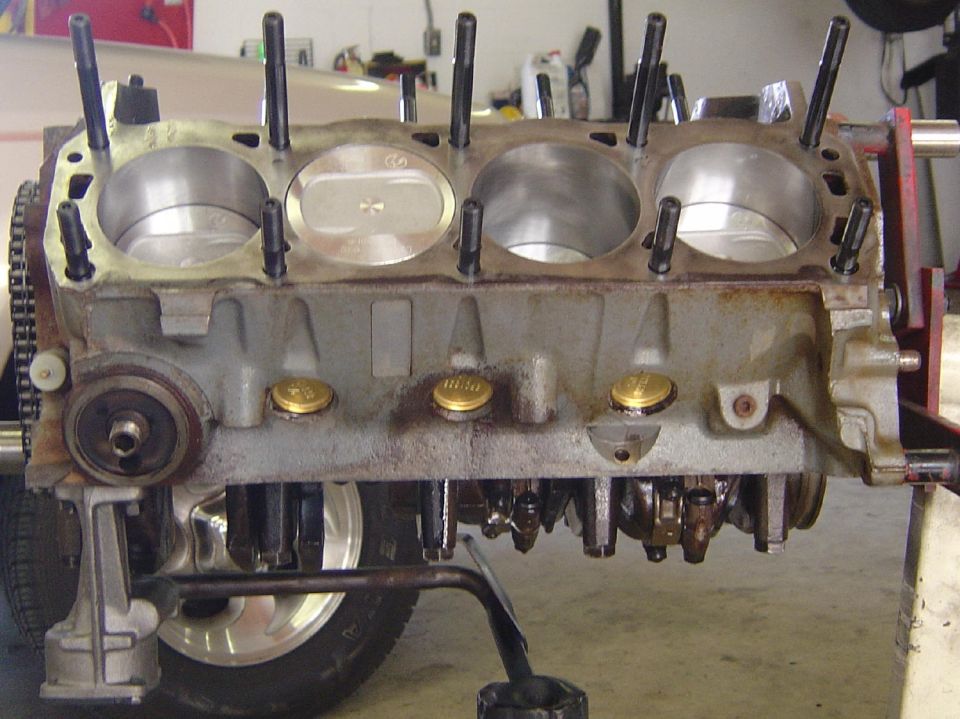 Engine block with pistons and crankshaft visible, on a stand
