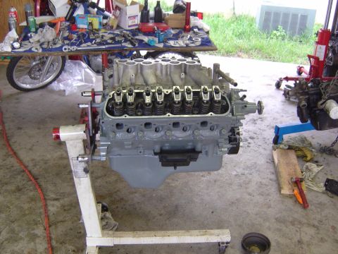 1993 Ford Bronco - Engine on a stand in a garage, with tools and parts on a table in the background.