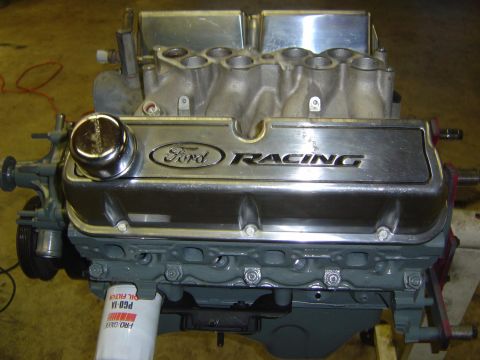 1993 Ford Bronco - A Ford Racing engine is shown with chrome valve covers and intake manifold, mounted on a stand.
