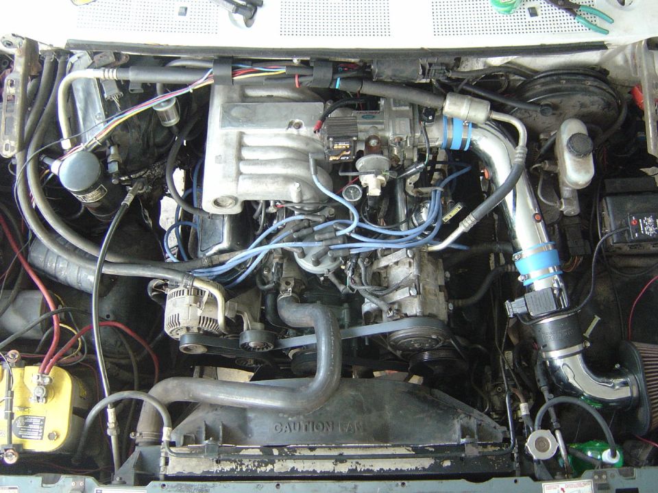 Engine bay with V8 engine, intake manifold, alternator, and battery