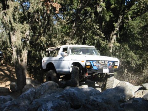1985 Ford Bronco - A white 1978 Ford Bronco navigates a rocky trail, demonstrating its off-road capabilities.