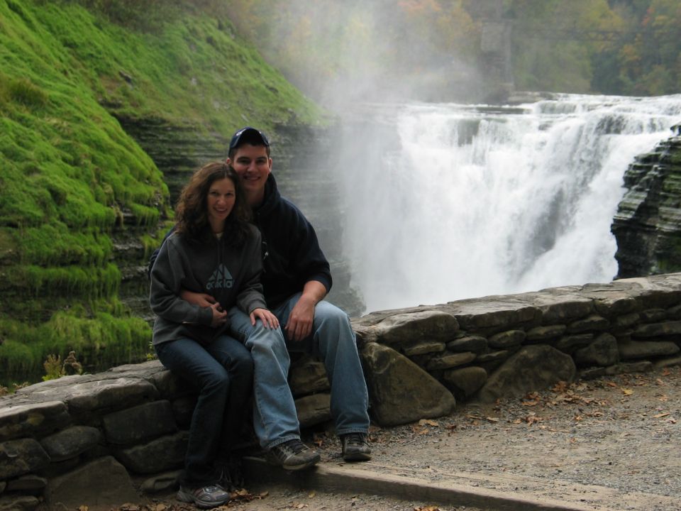 Couple sits before a waterfall, with Supermotors.net logo visible