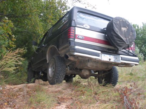 1988 Ford Bronco - Ford Bronco seen off-road with a spare tire mounted on the back.