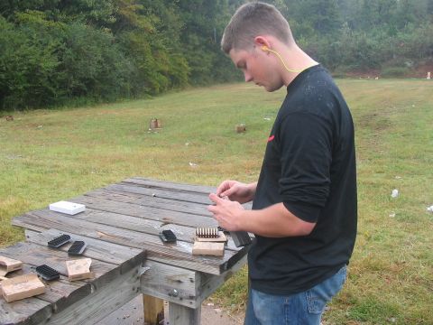 1988 Ford Bronco - A person prepares ammunition at a shooting range, with targets visible in the background.