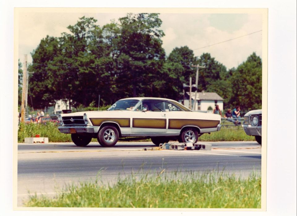 White 1966 Ford Fairlane with gold side panels and hood scoop at a drag strip, side view, number 85 on windshield