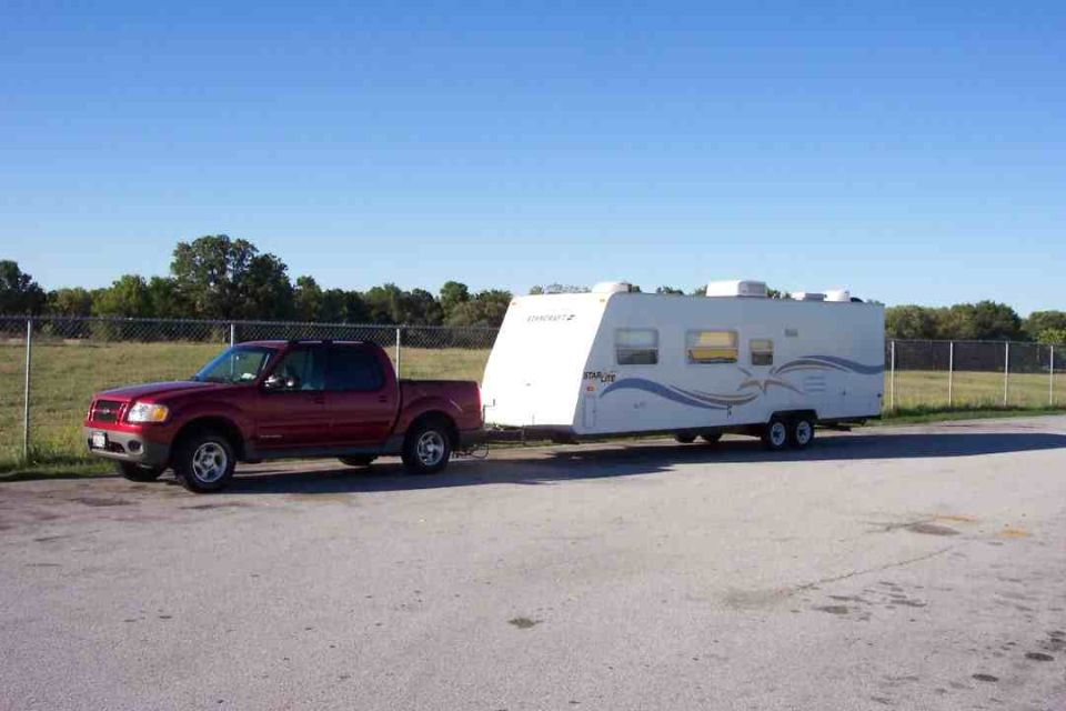 Red 2002 Ford Sport Trac towing a white travel trailer