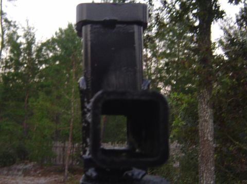 1993 Ford Bronco - A black trailer hitch receiver is shown against a backdrop of trees and sky.