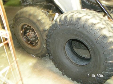 1978 Ford Bronco - Close-up of two large off-road tires, one mounted and one loose, with a date stamp in the corner.