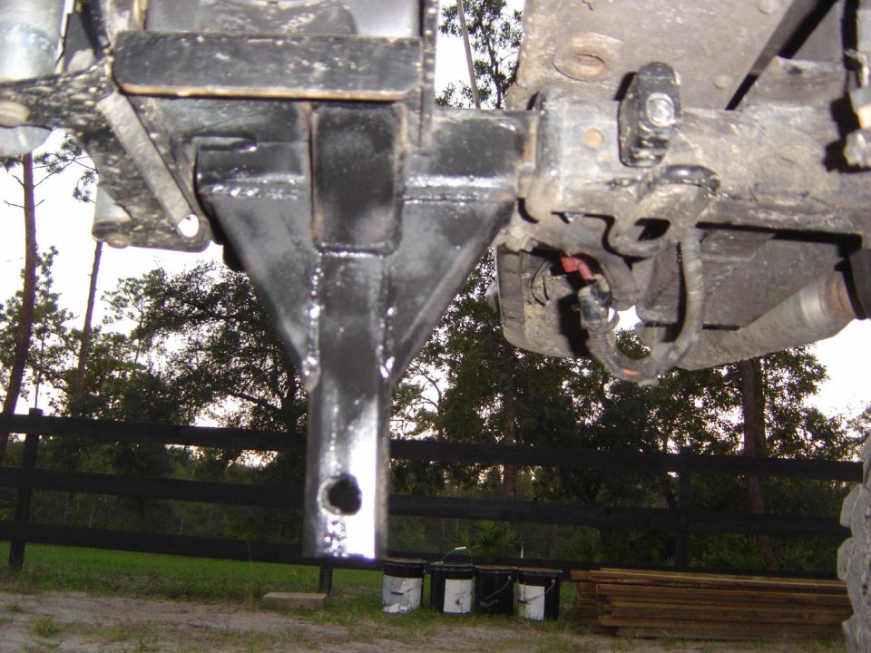 Trailer hitch receiver mounted under a vehicle, with wiring visible
