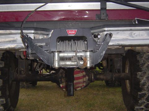 1993 Ford Bronco - A Warn winch is mounted to the rear of a vehicle, with the differential cover showing a red and white striped pattern.