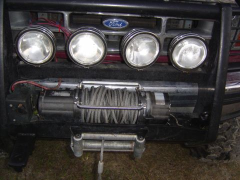 1993 Ford Bronco - Close-up of a Ford Bronco's front end, showing a brushguard, winch, and auxiliary lights.