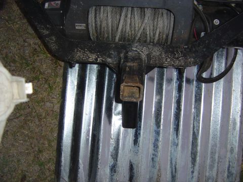 1993 Ford Bronco - Close-up view of a winch and trailer hitch assembly mounted on a corrugated metal surface.