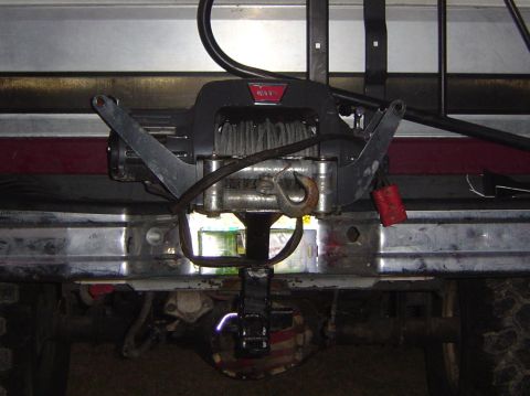 1993 Ford Bronco - A Warn winch is mounted to the front bumper of a vehicle, ready for use.
