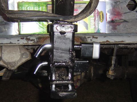 1993 Ford Bronco - Close-up of a trailer hitch receiver and lock, with packaging in the background.