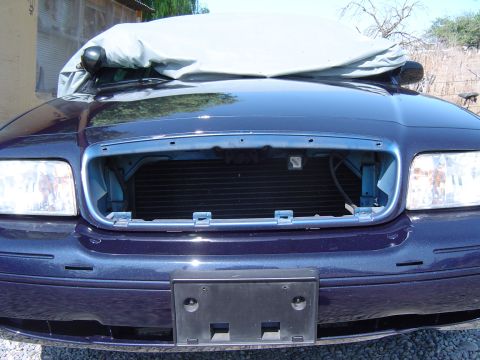 1999 Ford Crown Victoria - Front view of a Ford Crown Victoria with the grille removed, hood covered.