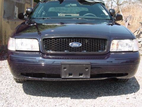 1999 Ford Crown Victoria - This Ford Crown Victoria features a honeycomb grille and aftermarket headlights, suggesting a model year different from the claim.