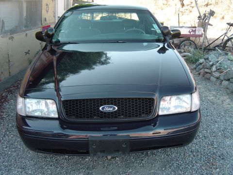 1999 Ford Crown Victoria - Front view of a black 1999 Ford Crown Victoria, a honeycomb grille and clear headlights.