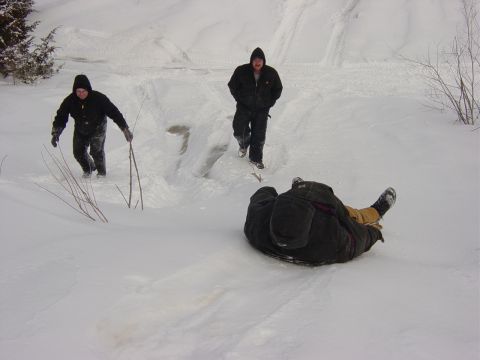 1983 Ford Bronco - Three individuals enjoy a winter day sledding down a snow-covered slope.