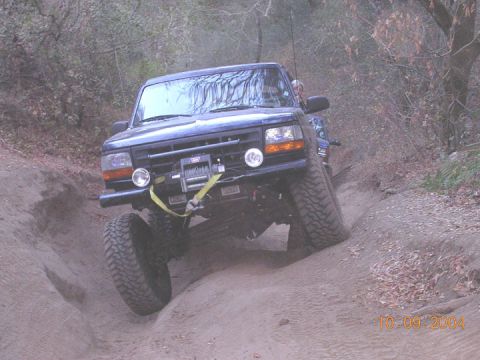 1994 Ford Bronco - This 1994 Ford Bronco is shown navigating a challenging off-road trail, equipped with a winch for assistance.