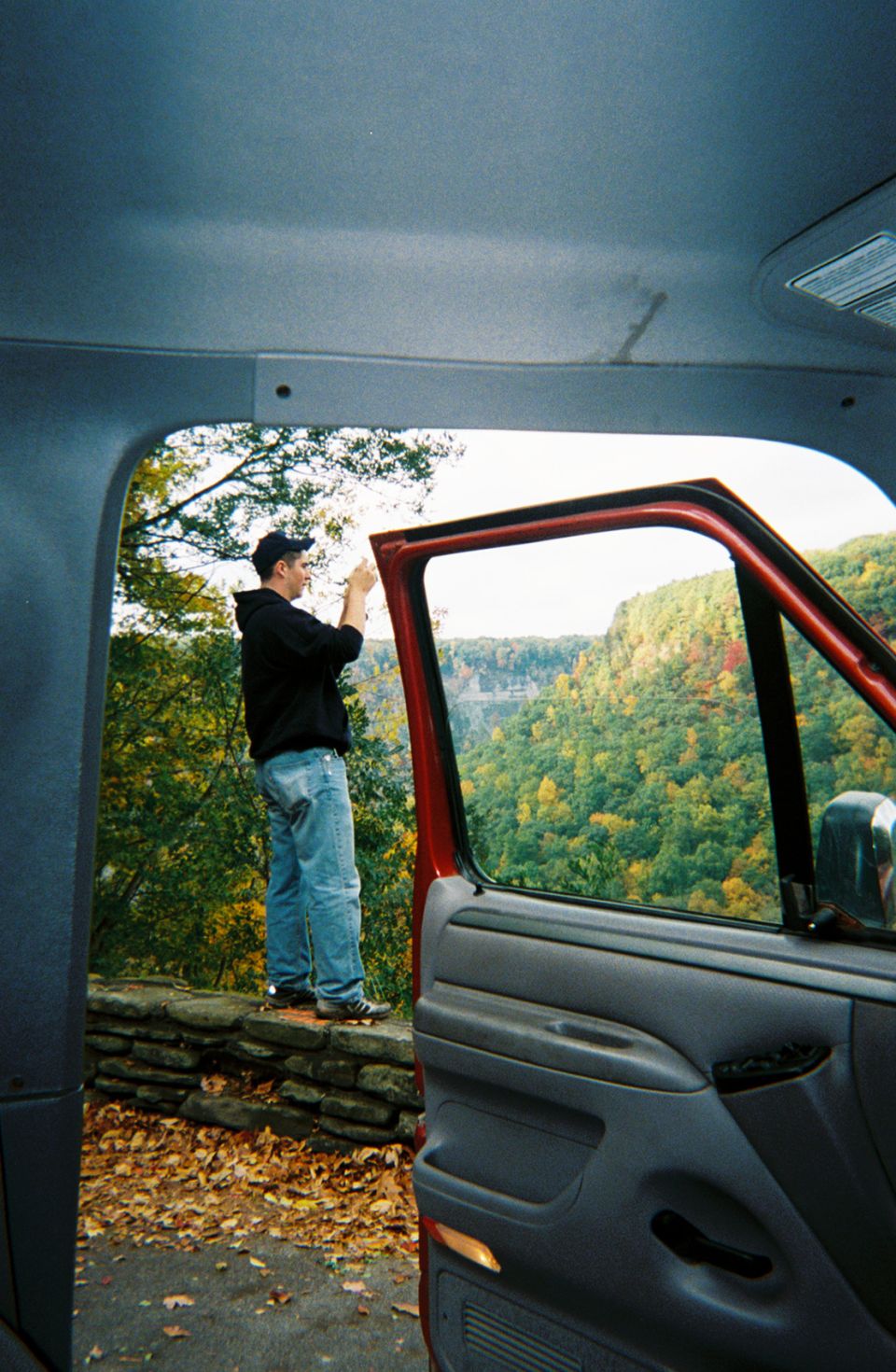 Red truck interior with open door showing person at scenic overlook