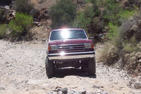 1992 Ford Bronco - This 1992 Ford Bronco navigates a , off-road path with a sun glare on its windshield.
