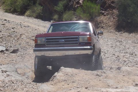 1992 Ford Bronco - Ford Bronco tackling a challenging rocky terrain on an off-road trail.