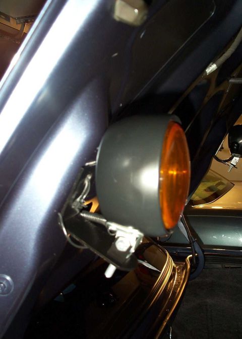 1998 Ford Crown Victoria - Close-up of an aftermarket amber light mounted to the underside of a vehicle's trunk lid.