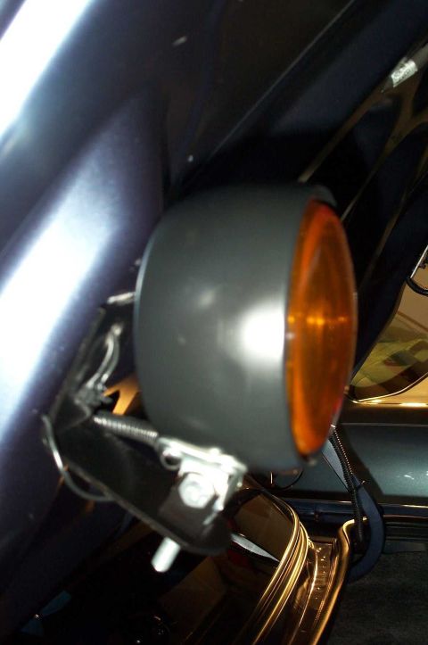 1998 Ford Crown Victoria - Aftermarket amber fog light mounted on a vehicle fender, not a factory part.