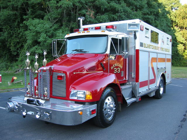 Red and white Glastonbury Fire Rescue 33 truck, front three-quarter view, trophies on the front bumper