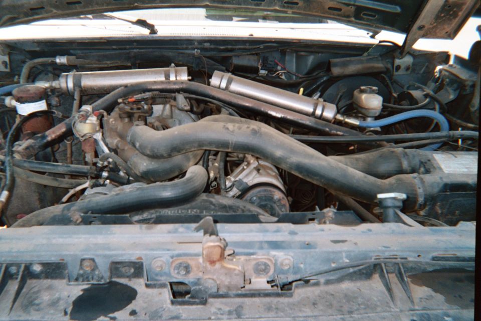 Engine bay with twin polished metal intercooler or intake tubes over a V engine