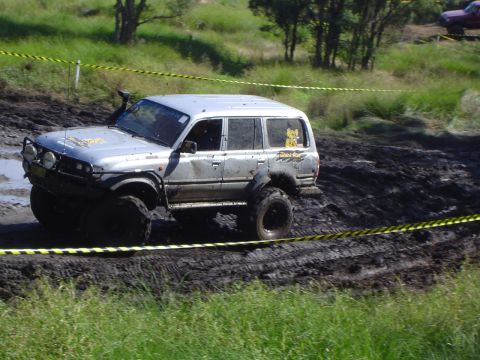 1982 Ford Bronco - This off-road vehicle navigates a challenging muddy track, demonstrating its capabilities in rough terrain.