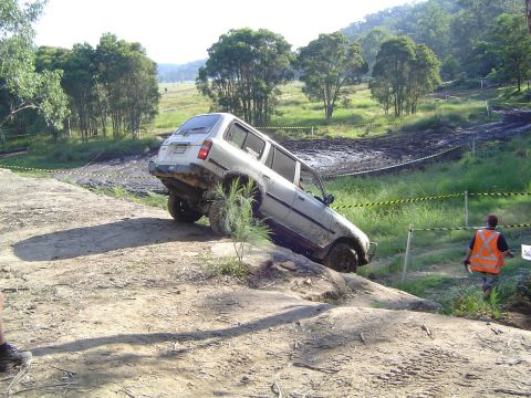 1982 Ford Bronco - An SUV navigates a challenging off-road course, demonstrating its capabilities on uneven terrain.