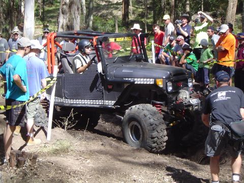 1982 Ford Bronco - An off-road vehicle navigates a challenging course with spectators watching.