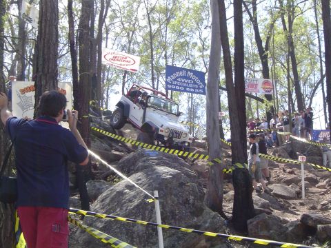 1982 Ford Bronco - A white Jeep Wrangler navigates a challenging rocky course during an off-road event.
