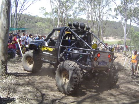 1982 Ford Bronco - Custom off-road buggy with extensive roll cage and large tires is seen from the rear.