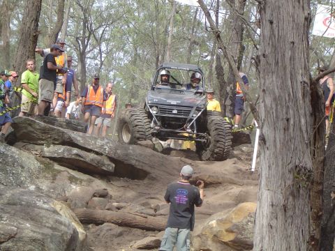 1982 Ford Bronco - A modified off-road vehicle tackles a challenging rocky terrain during an event, with onlookers observing the action.
