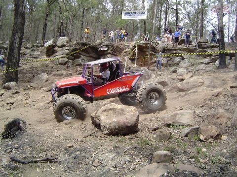 1982 Ford Bronco - A custom off-road buggy tackles a challenging rocky terrain during a competition.