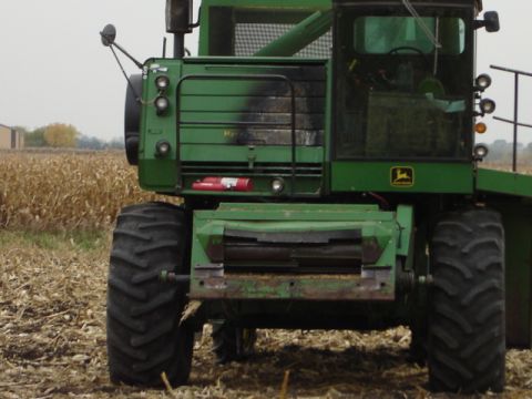 1992 Ford Bronco - A green combine harvester sits in a field of harvested corn.