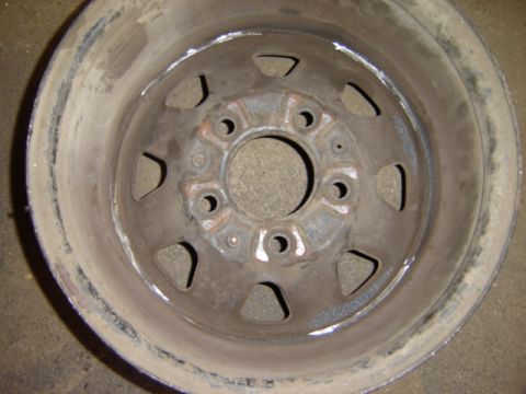 1992 Ford Bronco - This is a close-up view of a worn metal wheel rim, showing its lug nut pattern.