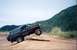1993 Ford Bronco - A black SUV is captured mid-air as it navigates a dirt path.